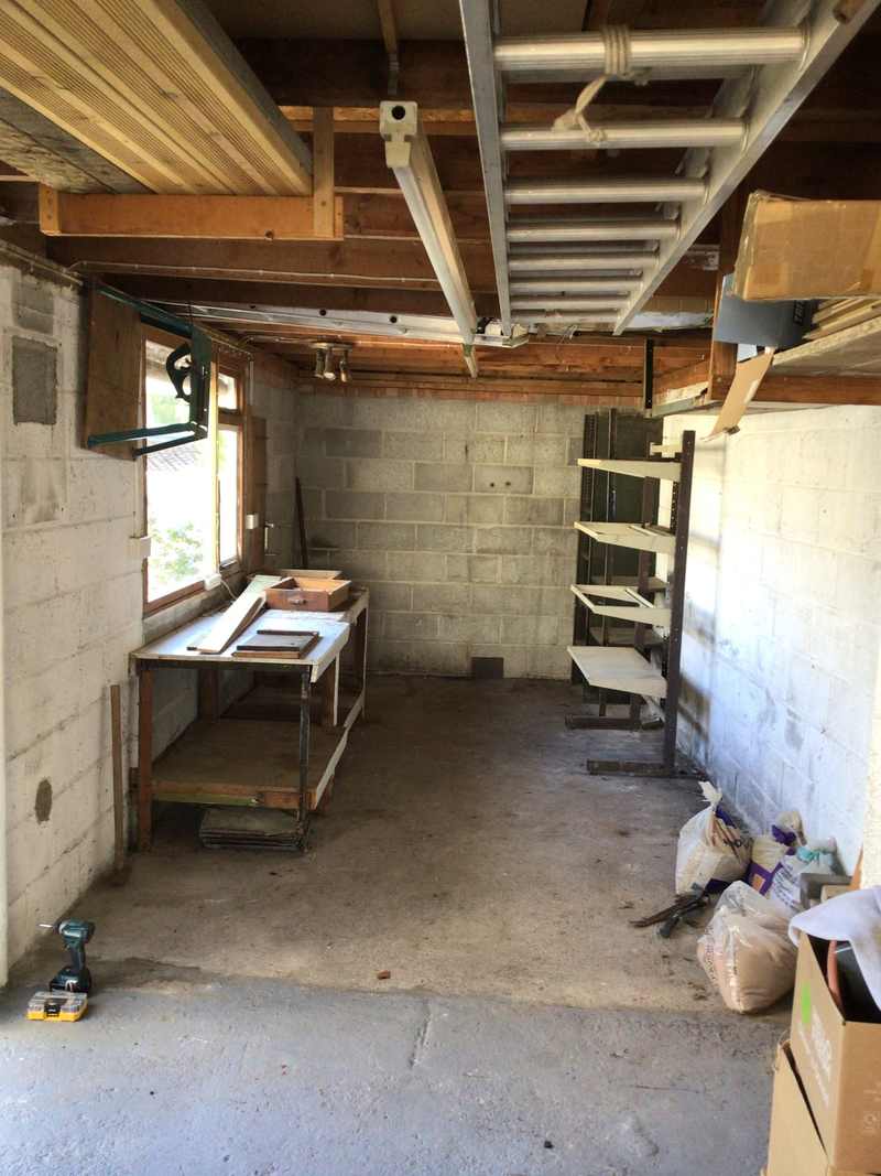 Garage before conversion — bare blockwork, exposed joists and a concrete floor